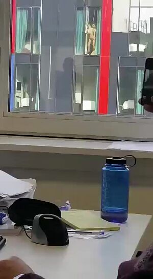 Board meeting cut short when they notice couple is fucking in building next door.