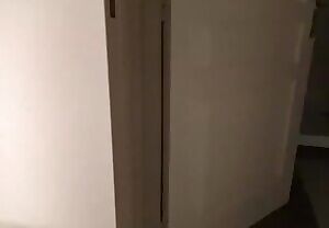 Her husband watches through the door