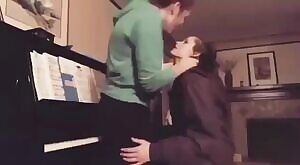 Making out with her friend on the Piano.