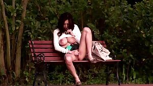 Playing with herself on a park bench